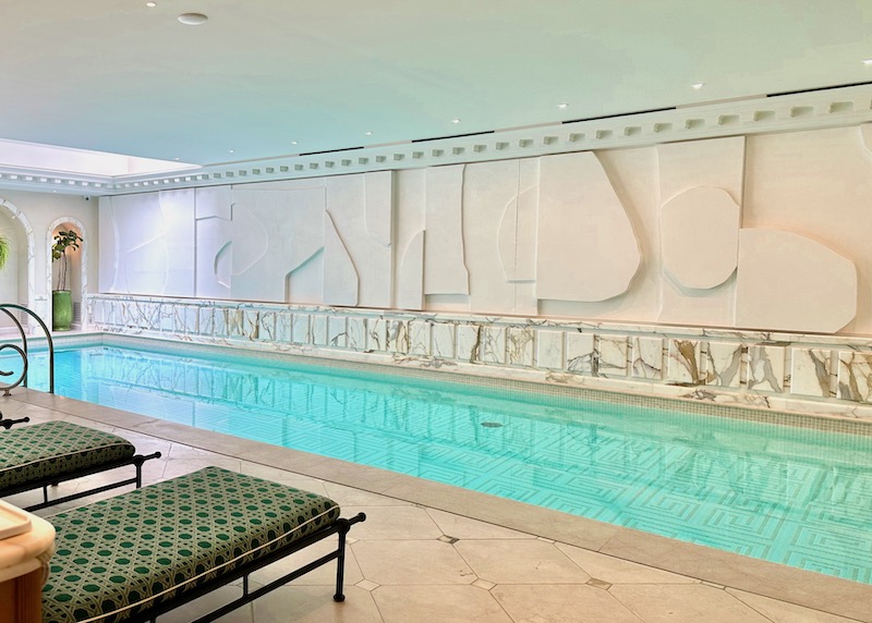 Lap pool inside the Saint James hotel wellness center with geometric and marble wall art and lounge chairs in the 16th Arrondissement of Paris