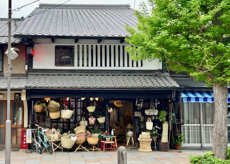 A small store front with baskets and hats hanging out front.
