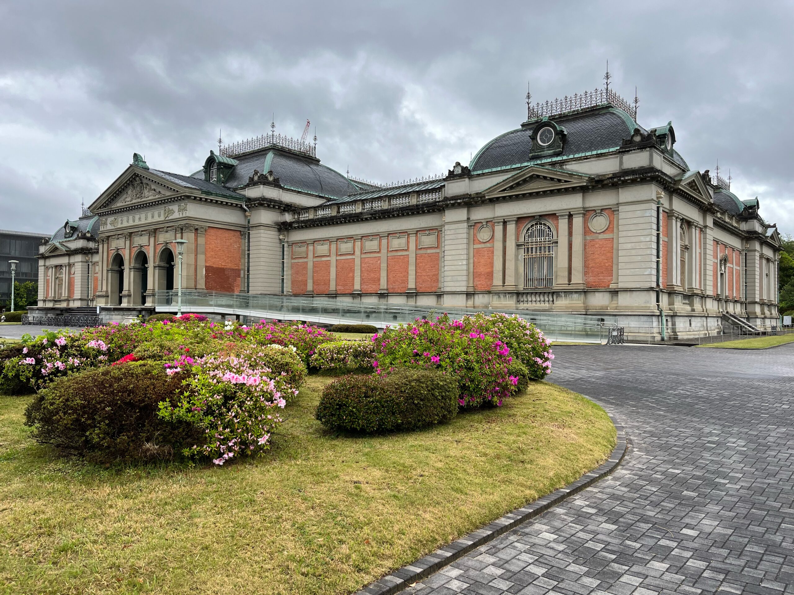 The Kyoto National Museum is a brick and stone building with a green copper roof and ornate railed look outs.
