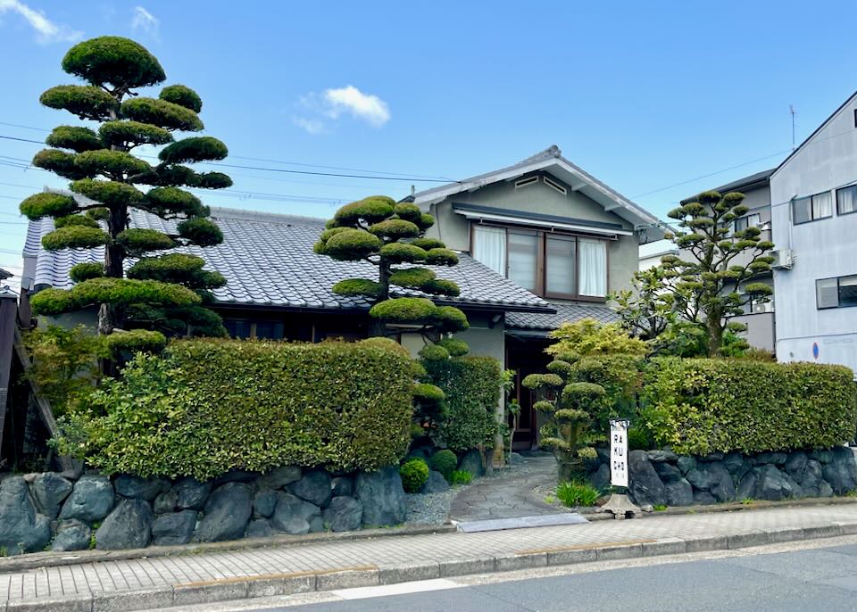 A house in Kyoto with lots of green trees in the yard.