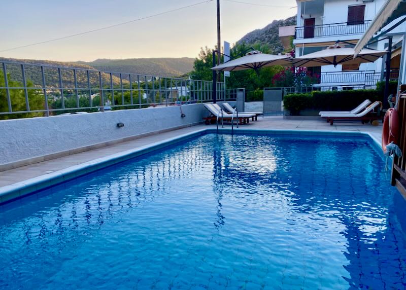 Blue hotel swimming pool with mountain view at dusk