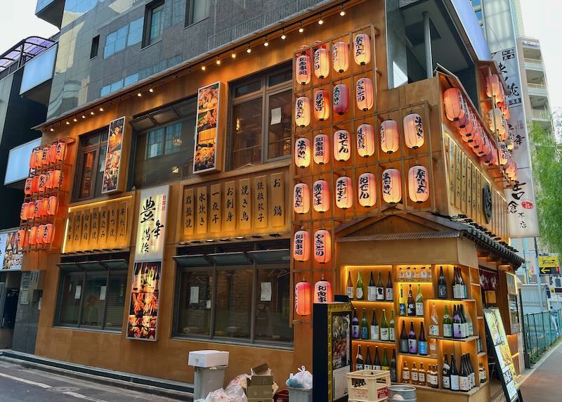 Building lined with Japanese lanterns and backlit bottles 