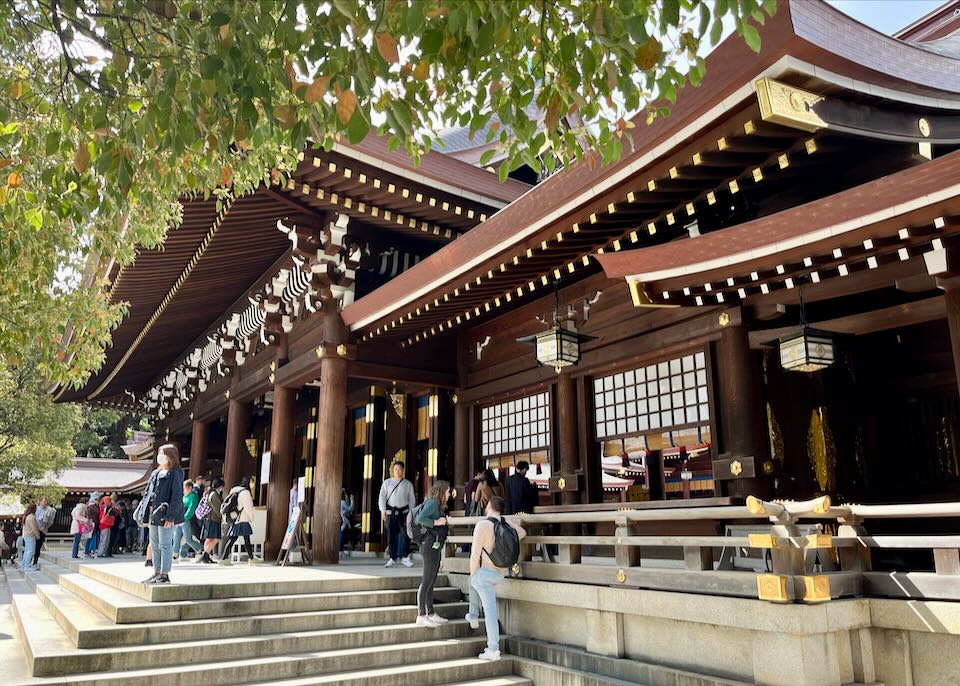 Visitors pose for photos in front of a wooden Japanese temple