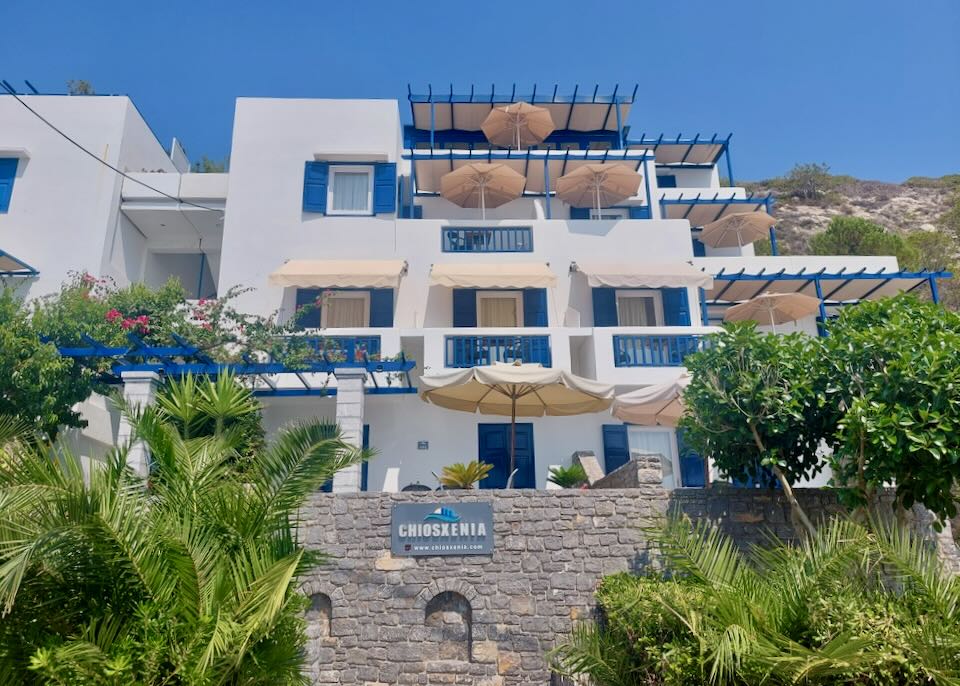 White boxy becah hotel with blue trim and sun umbrellas