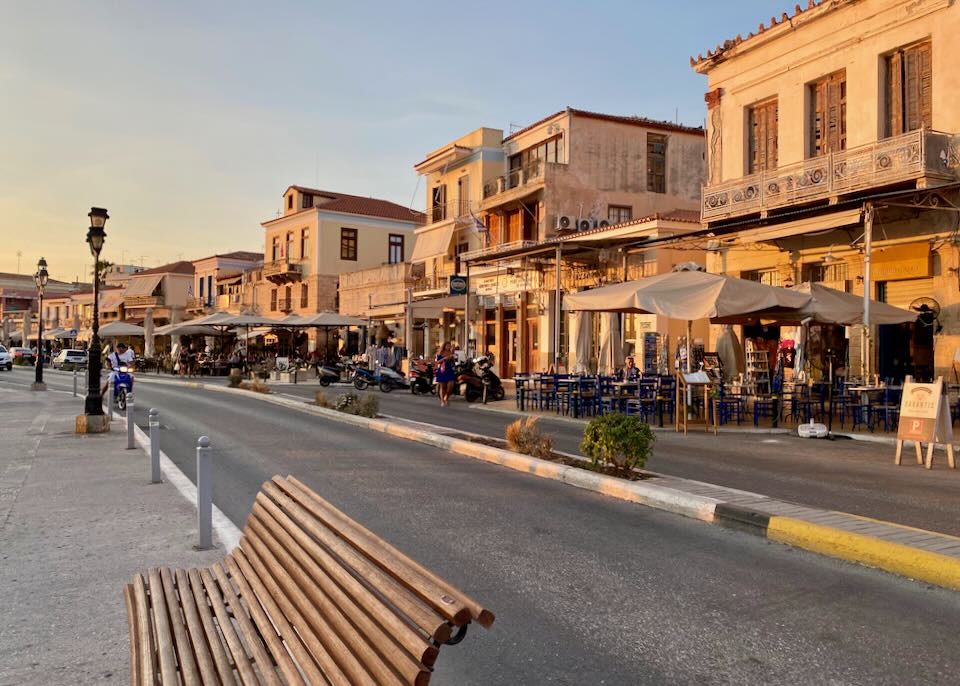 A street lined with rustic neoclassical and venetian buildings, glowing in the sunset light