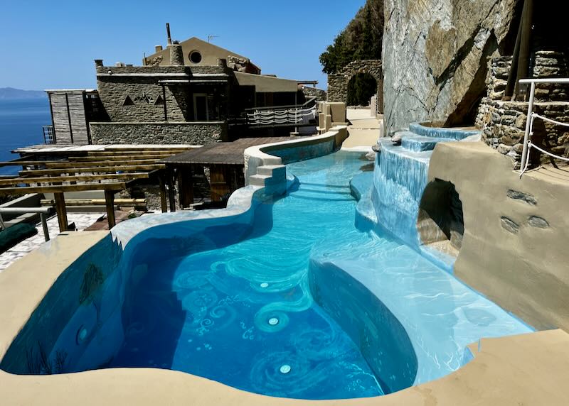 Free-form pool with waterfall overlooking the blue sea