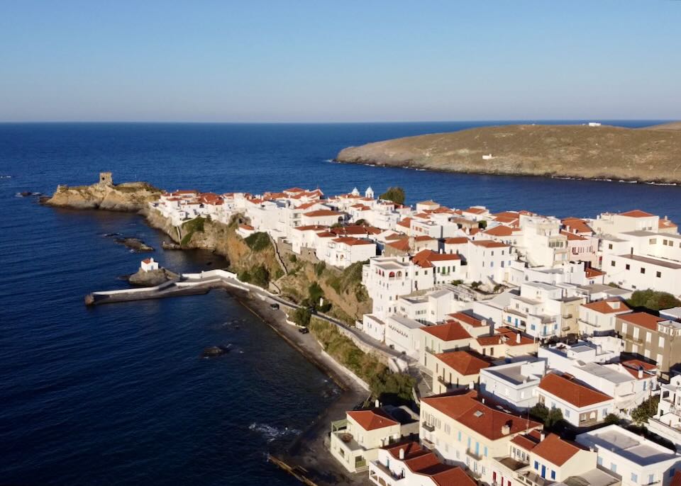 White buildings with red tiled roofs on a peninsula jutting into the sea