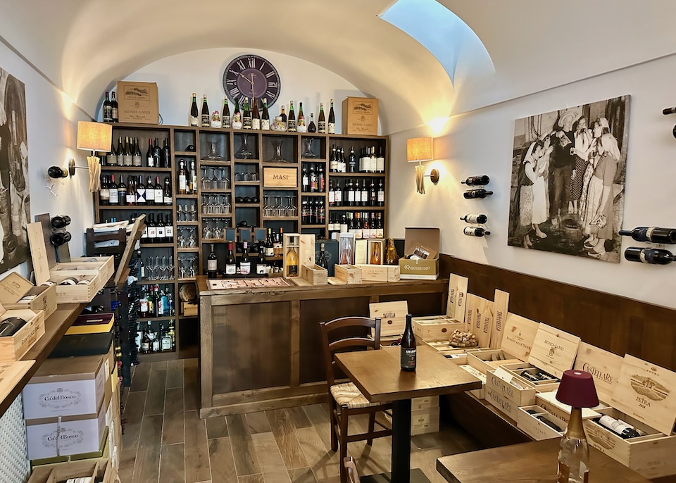 The wine room with shelves full of wine bottles and wooden boxes full of wine at Capri Wine Hotel in Marina Grande, Capri
