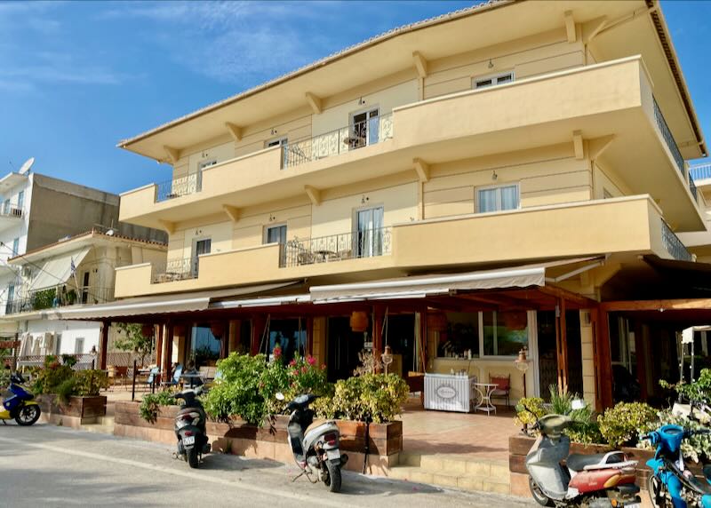 Saffron yellow hotel with balconies, with motorcycles parked in front