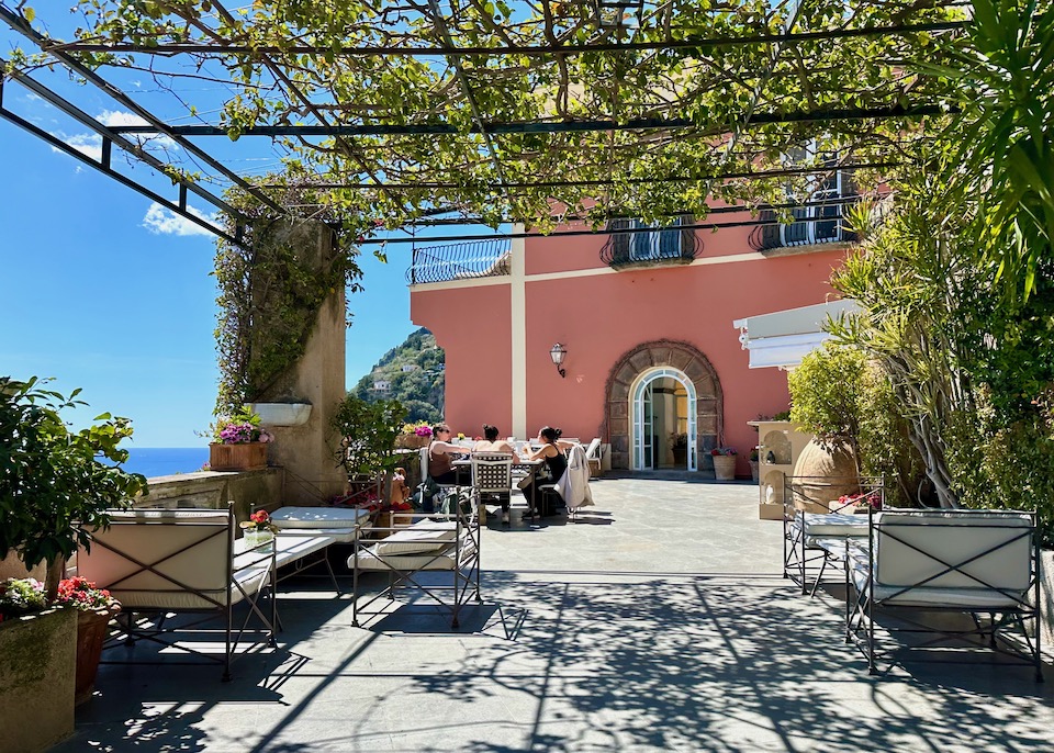 A vine covered pergola over a dining terrace at Villa Magia in Positano on the Amalfi Coast.