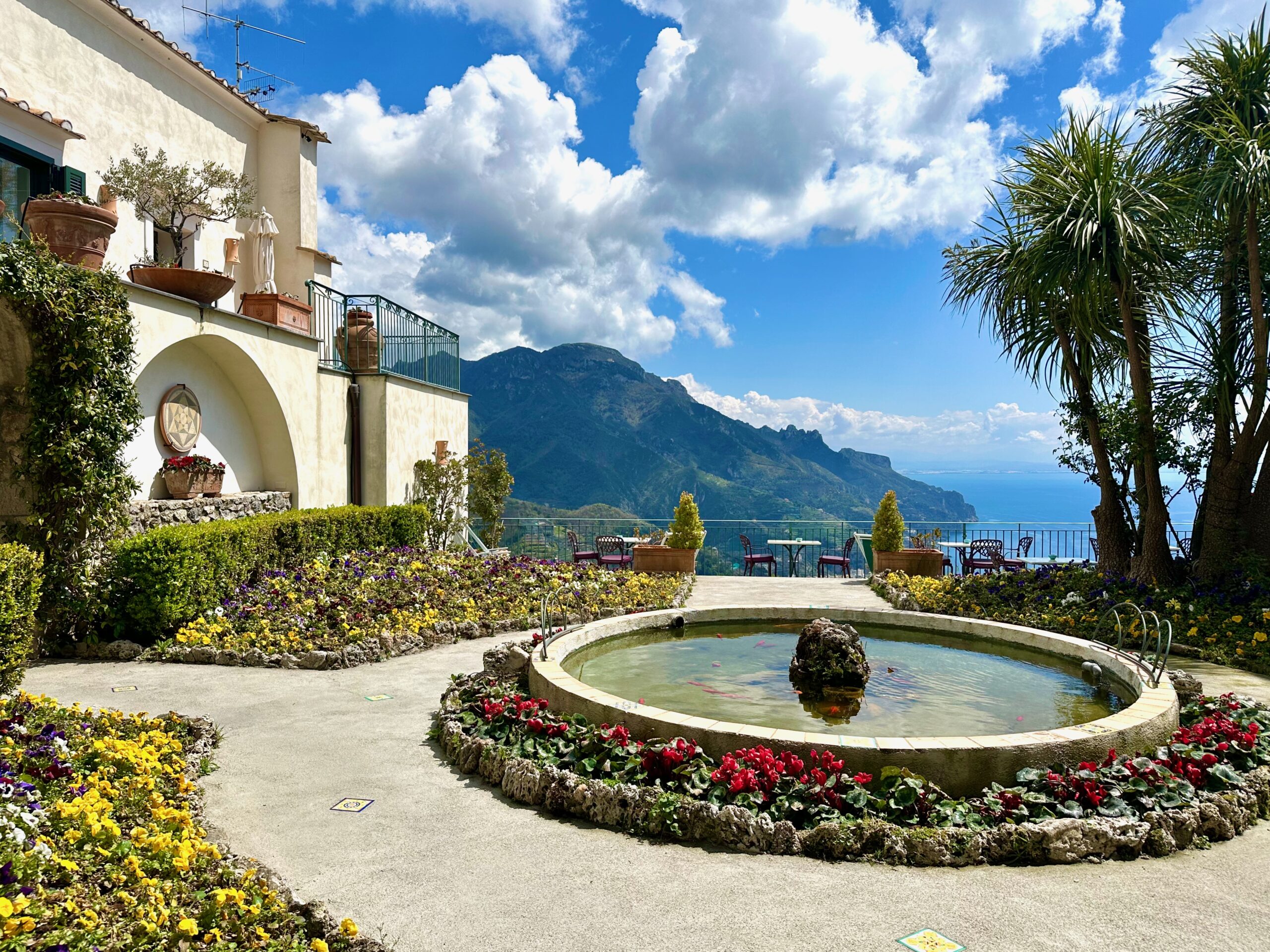 Garden in bloom with a koi pond and view to the sea and mountains at Parsifal hotel in Ravello on the Amalfi Coast