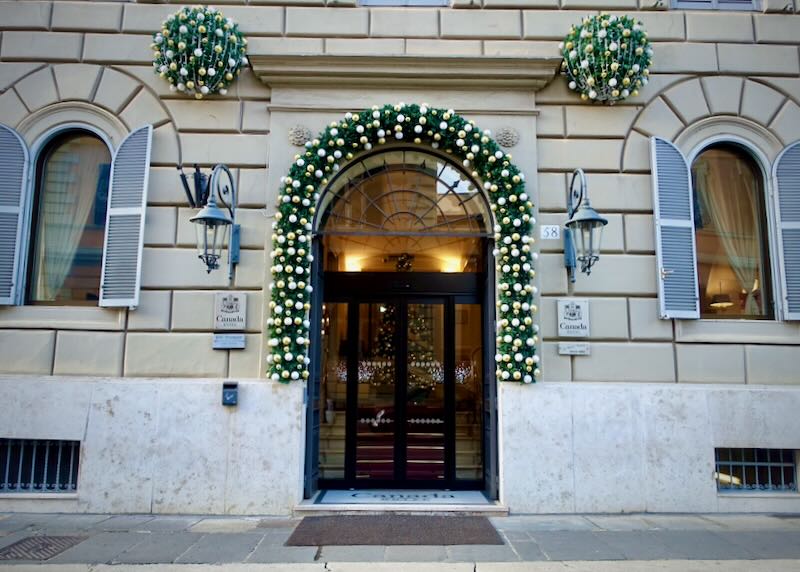 Arched hotel doorway, decorated with greenery and lights for the winter holidays.