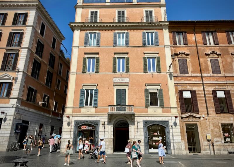 Salmon-colored hotel on a pedestrianized square in Rome.