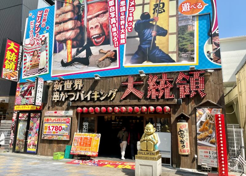 Colorful posters of King Kong, ninjas, and electric signs adorn a restaurant.