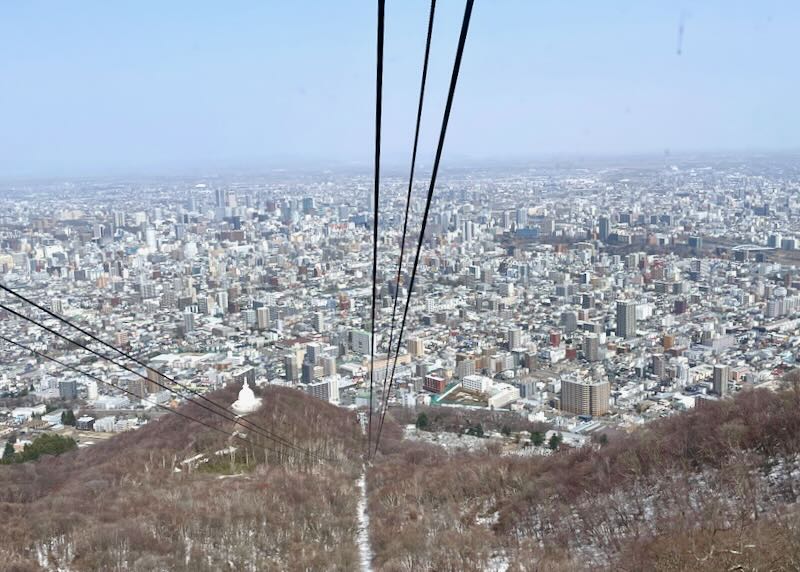 View of a large city from a cable car.