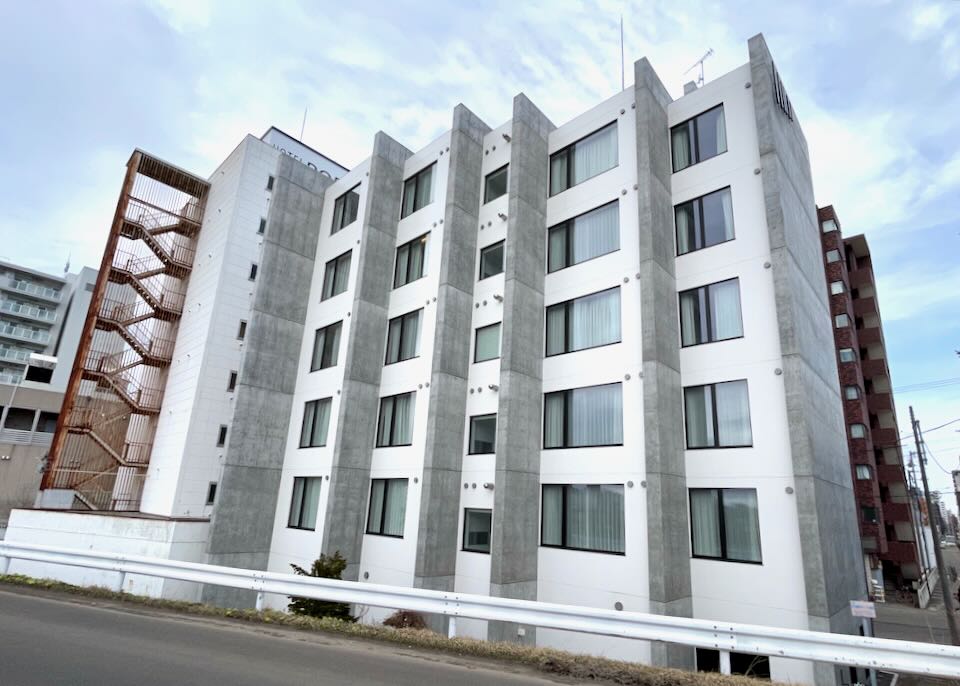 A 6-story hotel with a white exterior and cement supports.