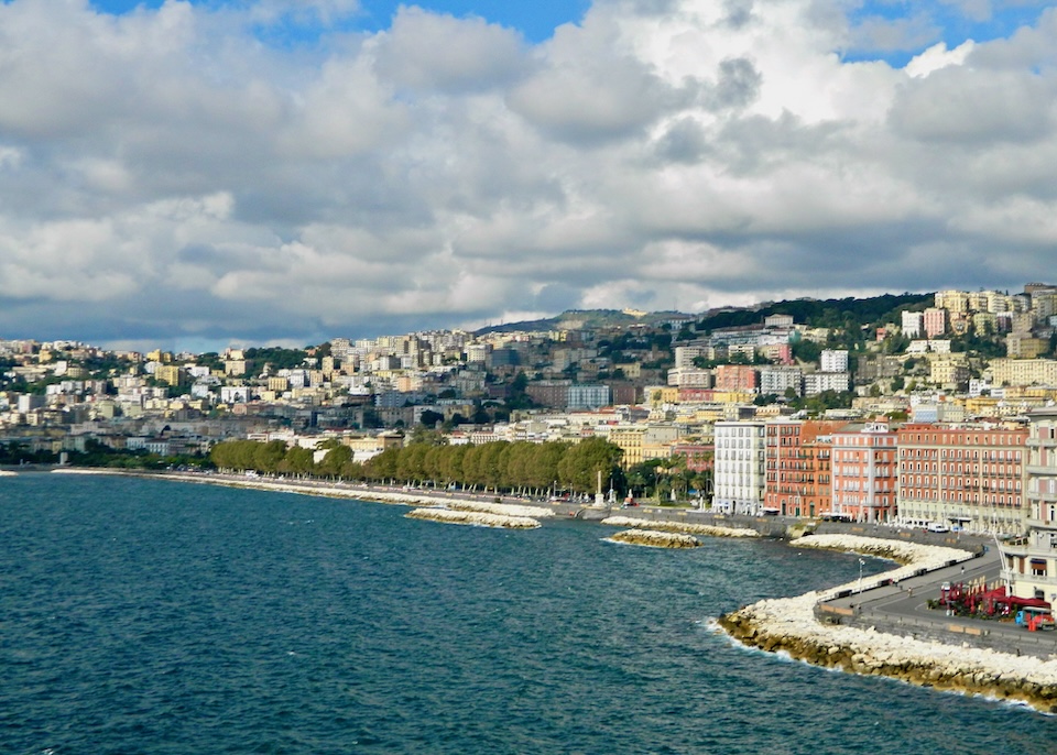 View toward the Chiaia neighborhood with the Lungomare promenade on the seafront, Villa Comunale park, and the hill of Vomero in Naples, Italy