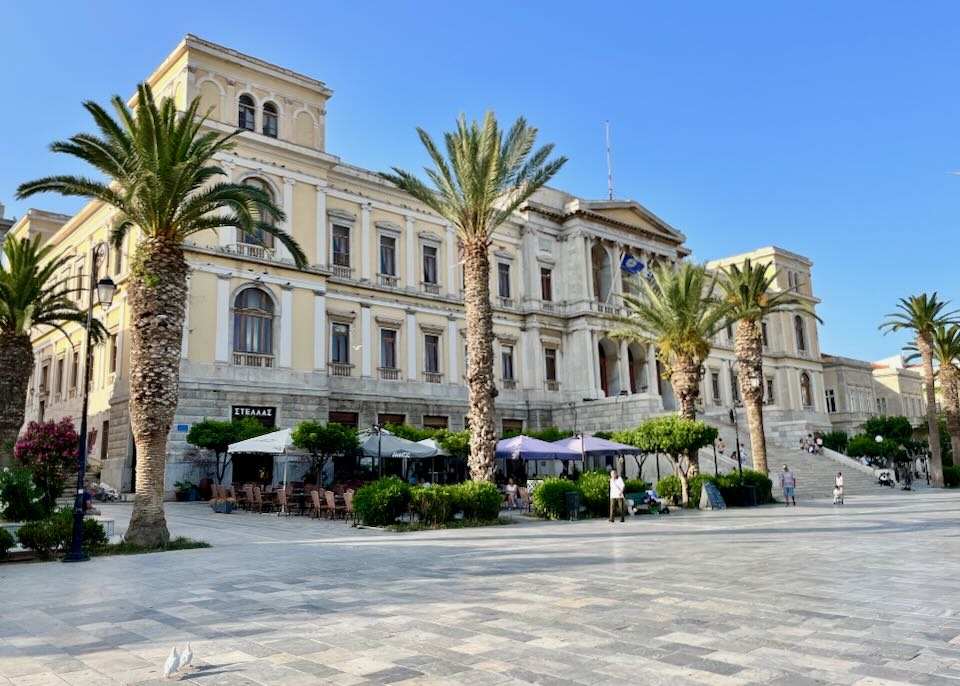 Large neoclassical building with palm trees in front.