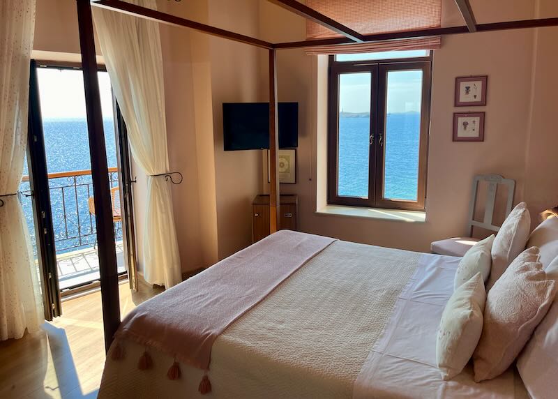 Hotel bed next to windows with a sea view