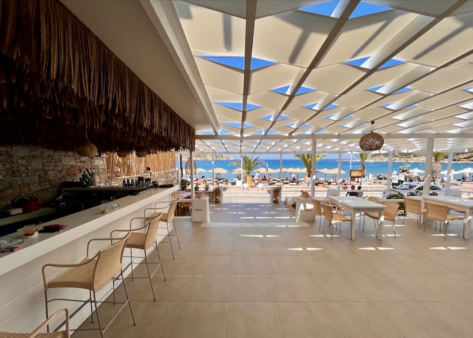 Indoor-outdoor beach bar with shaded table seating and 