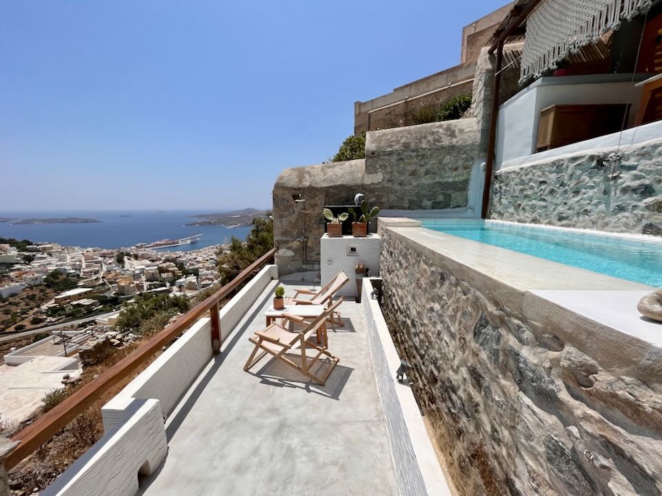 A small, rustic swim terrace overlooking a Greek village and the sea