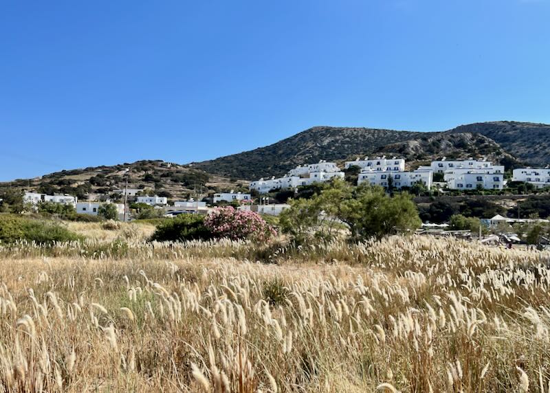 Sandy Dunes leading to a Greek village of boxy white buildings
