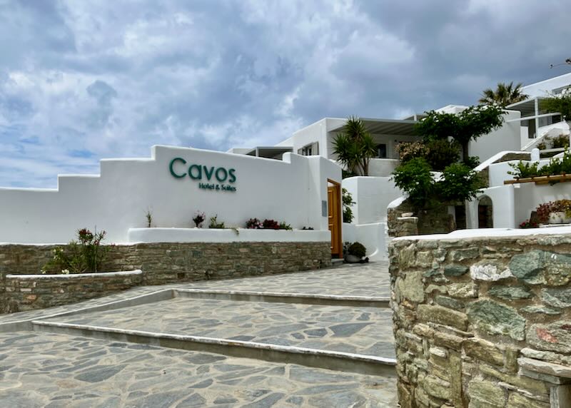Stone steps leading to the entrance of a white, Cycladic-style hotel