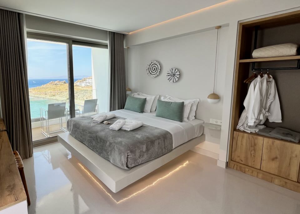 Hotel room with crisp casual and modern furnishings, and a balcony with sea view