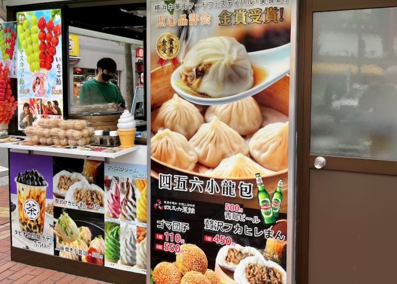 A person purchases food from a stall in Chinatown, Yokohama, Japan.