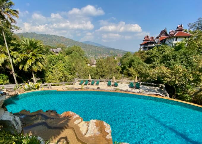 A pool with a view of the green hills.
