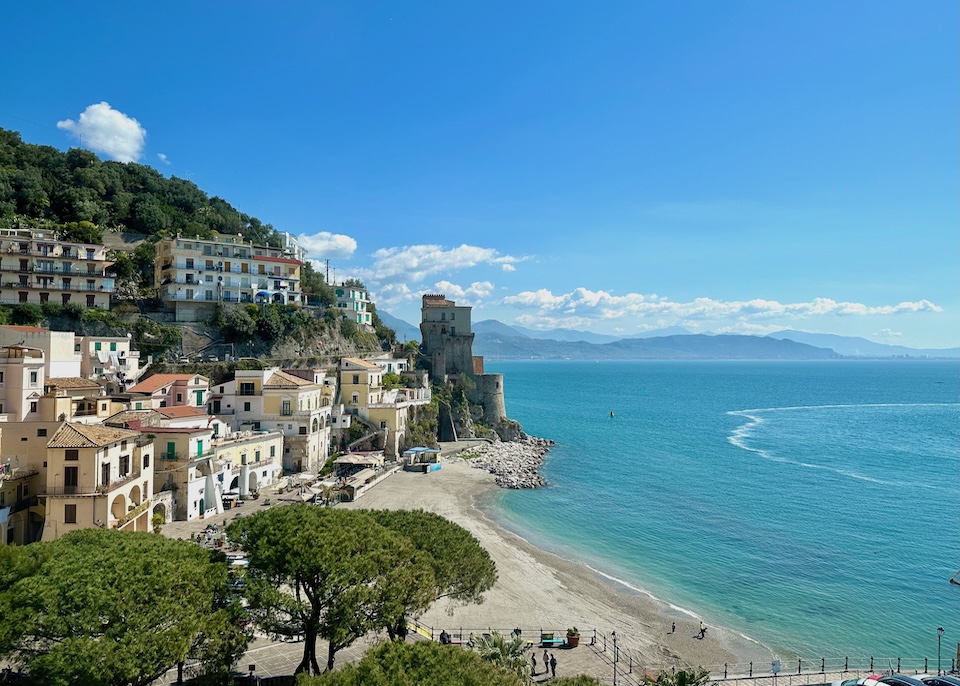 A sandy beach in front of the small town of Cetara with its landmark Viceregal Tower in the background on the Amalfi Coast