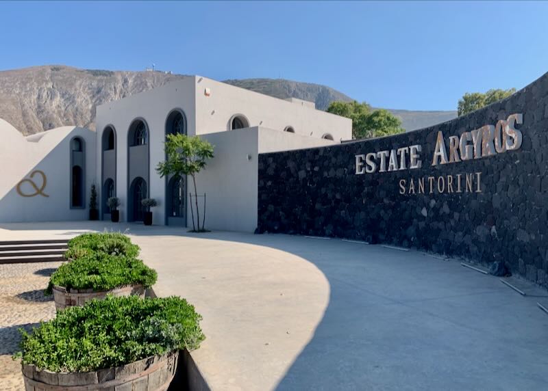 Exterior of a modern winery building with volcanic hills in the background