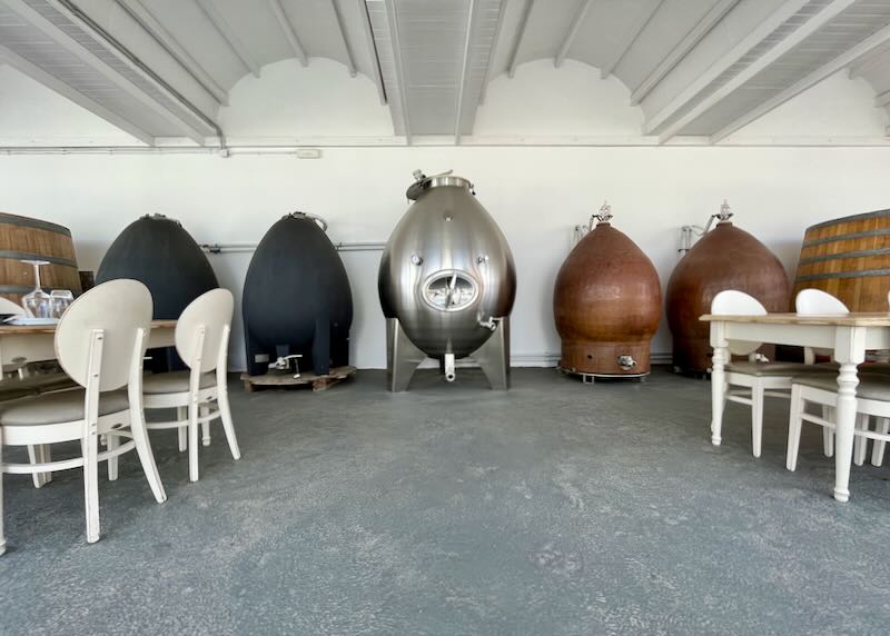 Tables set near large wine casks.