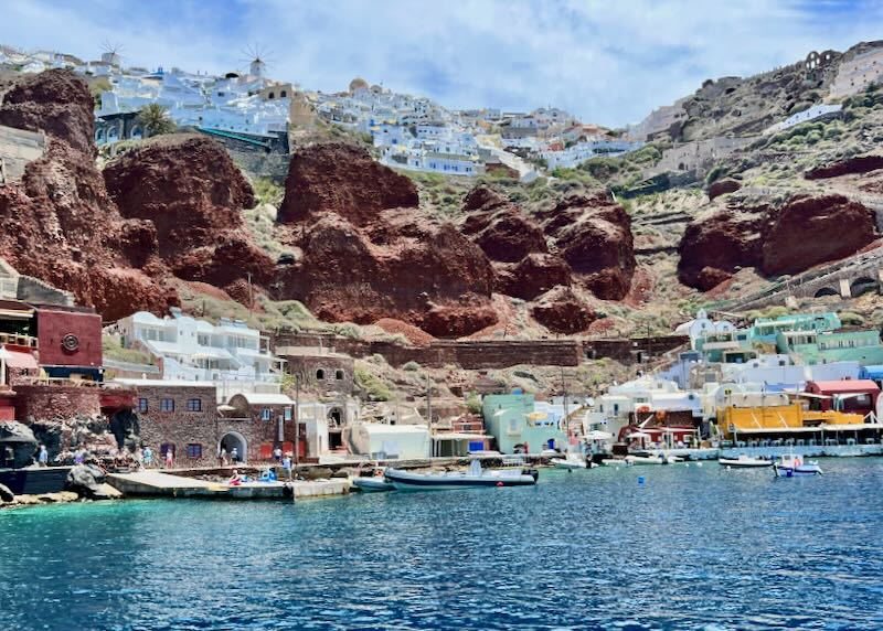 View of a small bay, lined with colorful buildings set into steep cliffs