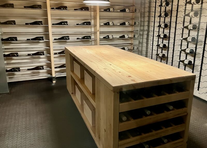 Climate-controlled wine storage with shelves and a butcher-block island