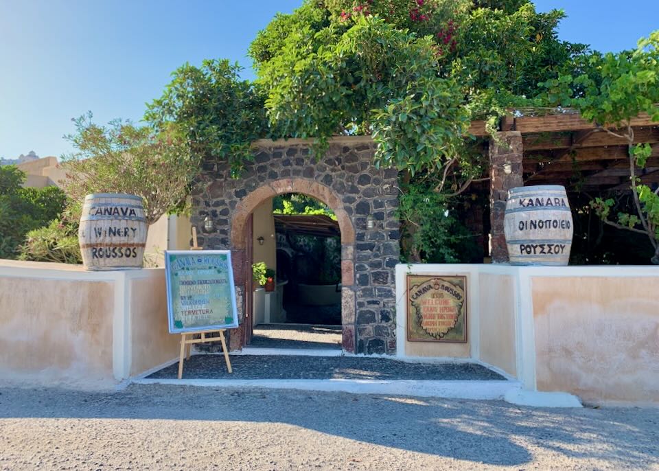 stone winery entrance with signs and foliage