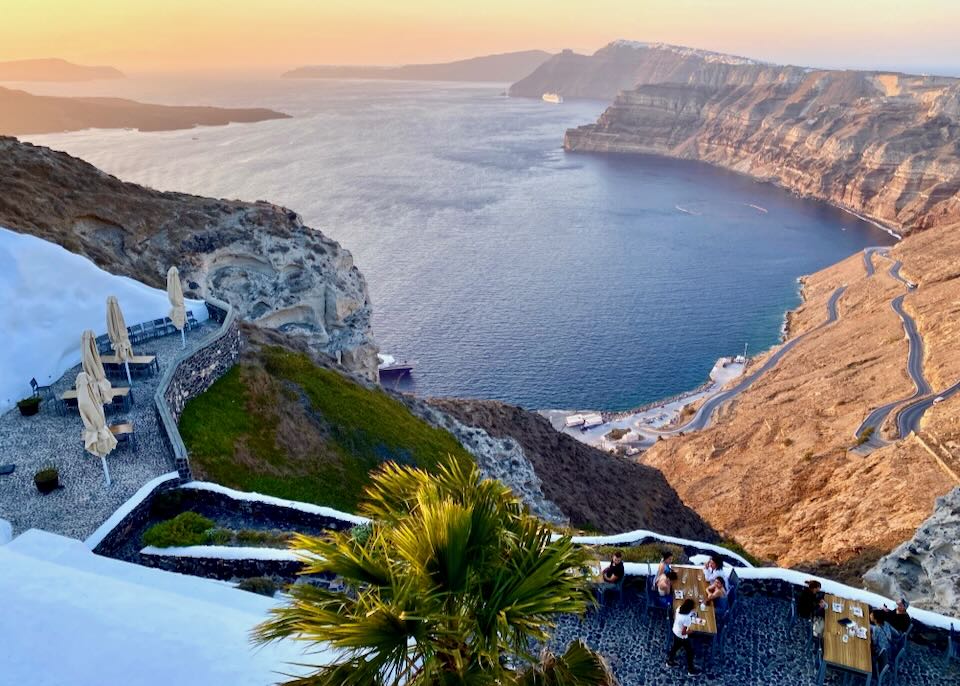 View over a winery tasting patio to the Santorini Caldera at sunset