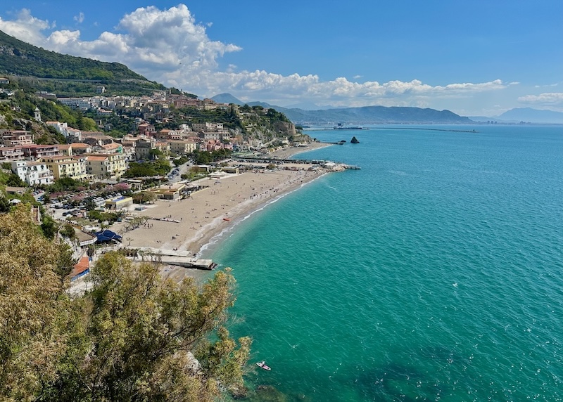 View from above a wide sandy beach with two piers and a quaint village at Vietri sul Mare on the Amalfi Coast