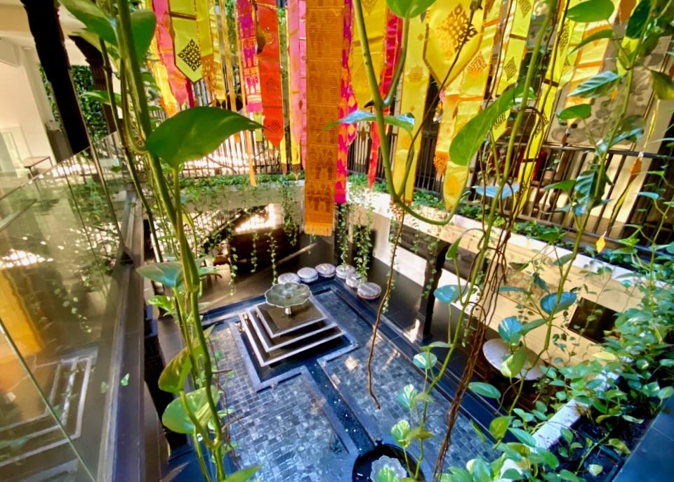Plants and colorful ribbons hang in an atrium.
