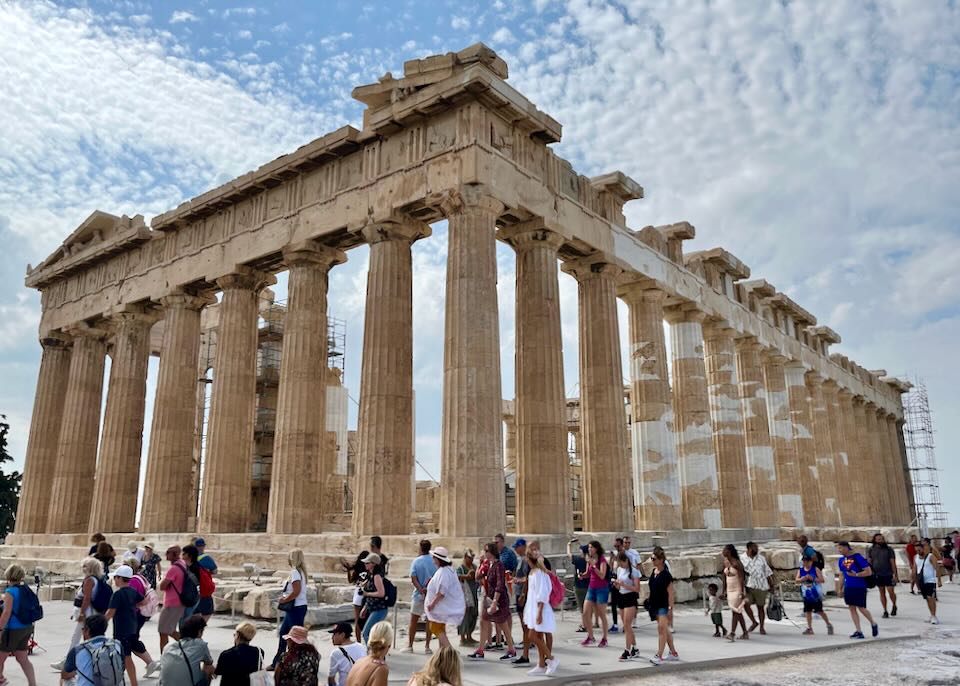 Visitors walk around the base of the Parthenon in Athens