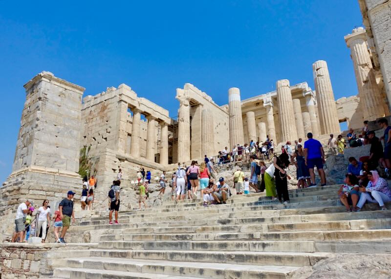 Tourists on the steps of the ancient main entrance to the Athens Acropolis
