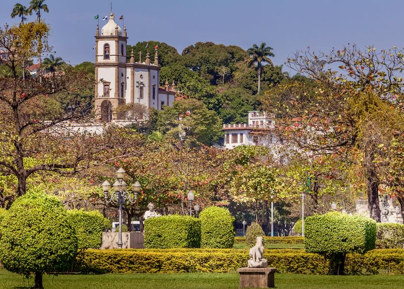 Beautiful colonialist church in Brazil, seen through trees and foliage