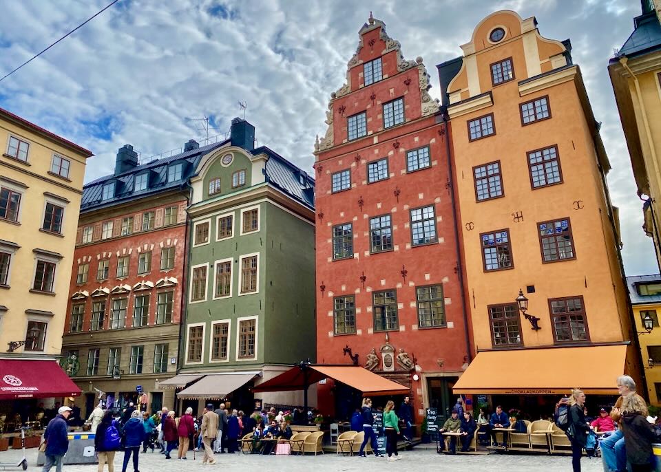 Cobbled pedestrian square surrounded by colorful Swedish buildings