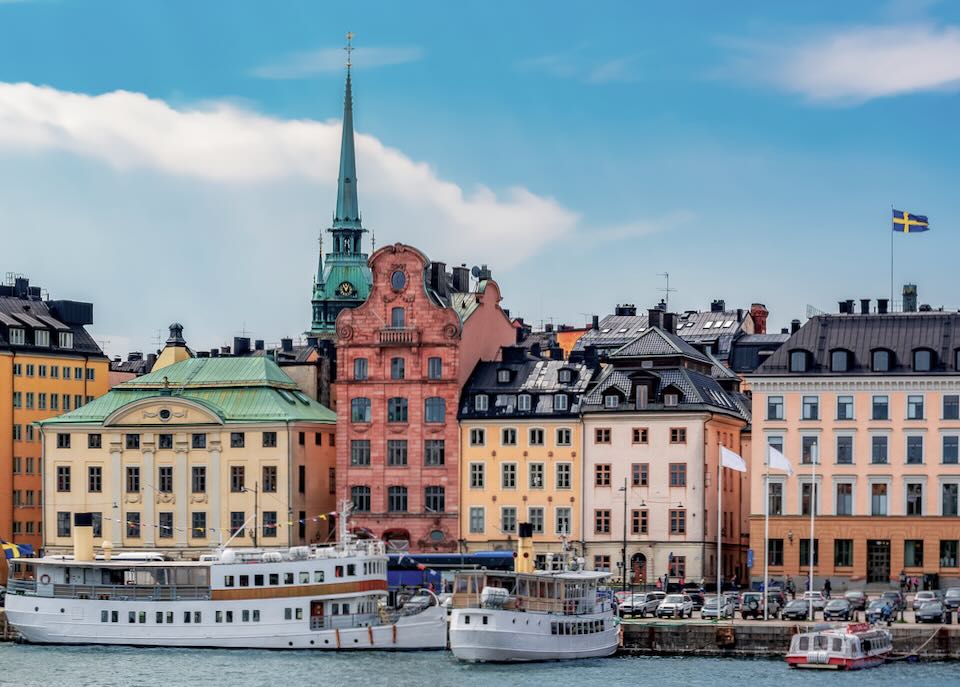 Colorful buildings and boats on Skeppsbron embankment in Stockholm old town (Gamla Stan), Sweden