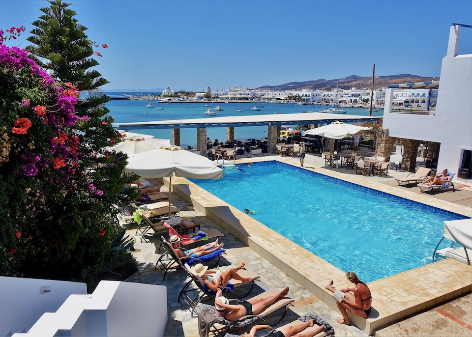 Sea view pool lined with sunbeds and bougainvillea at Kouros Village in Antiparos