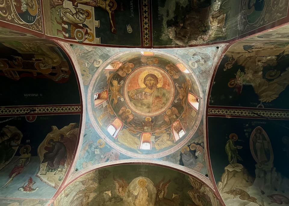 View looking up at a church dome, painted with icons