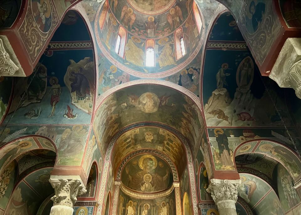 Elaborately decorated domed ceiling in a Greek Orthodox church.