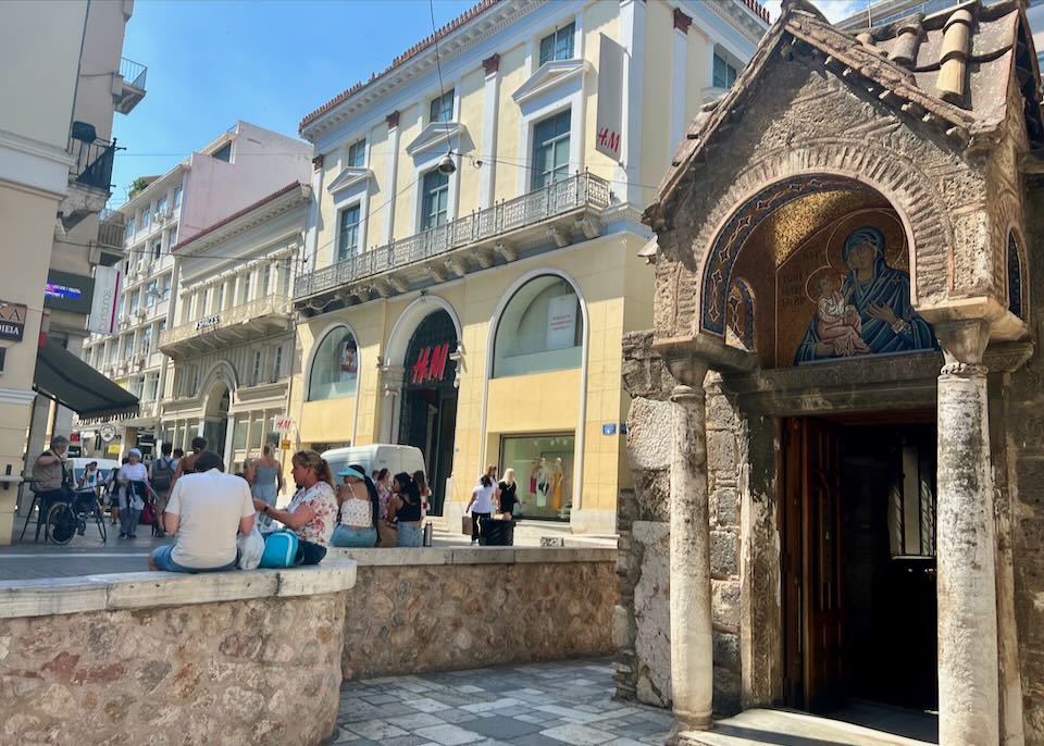 The doorway to Panagia Kapnikarea church in Athens, with shops in the background