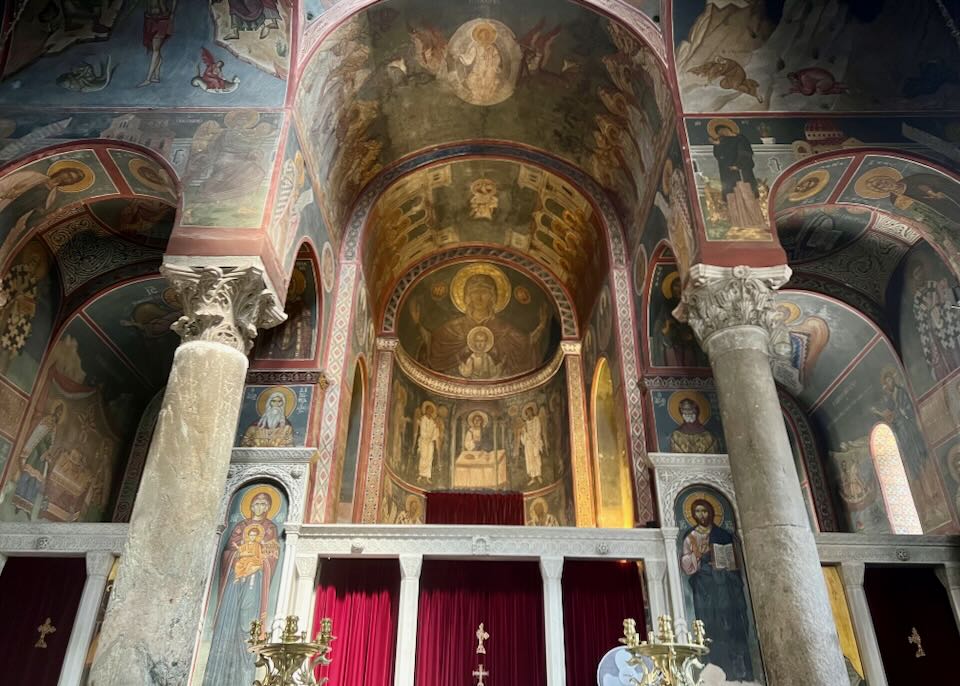Ornate paintings behind the altar of a Greek Orthodox church.