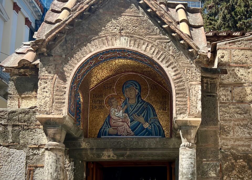 Mosaic of the Madonna and child above a stone doorway of a Byzantine church.